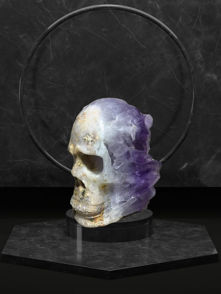 A crystal skull carved into an amethyst geode